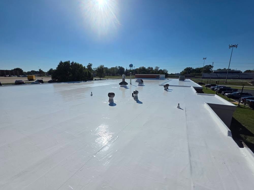 Commercial flat roof silicone coating — wide view with blue sky
